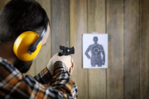 home defense pistol - JSD Supply | Premier Gun Parts And Accessories Man at an indoor shooting range aiming his pistol at a target in the distance