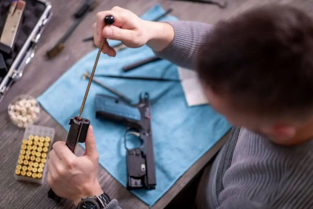 Overhead view of a man cleaning his disassembled firearm