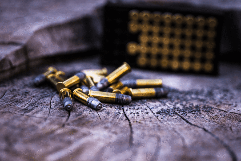 ammo on wood - JSD Supply | Premier Gun Parts And Accessories a pile of ammunition sitting on a tree stump