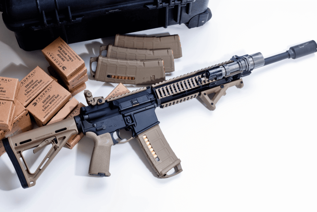 AR-15 laying next to magazines and rounds of ammunition