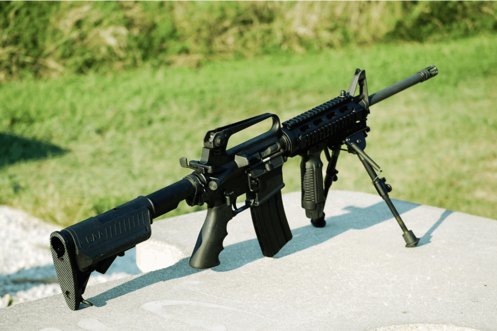 black AR-15 sitting on an outdoor table at a shooting range
