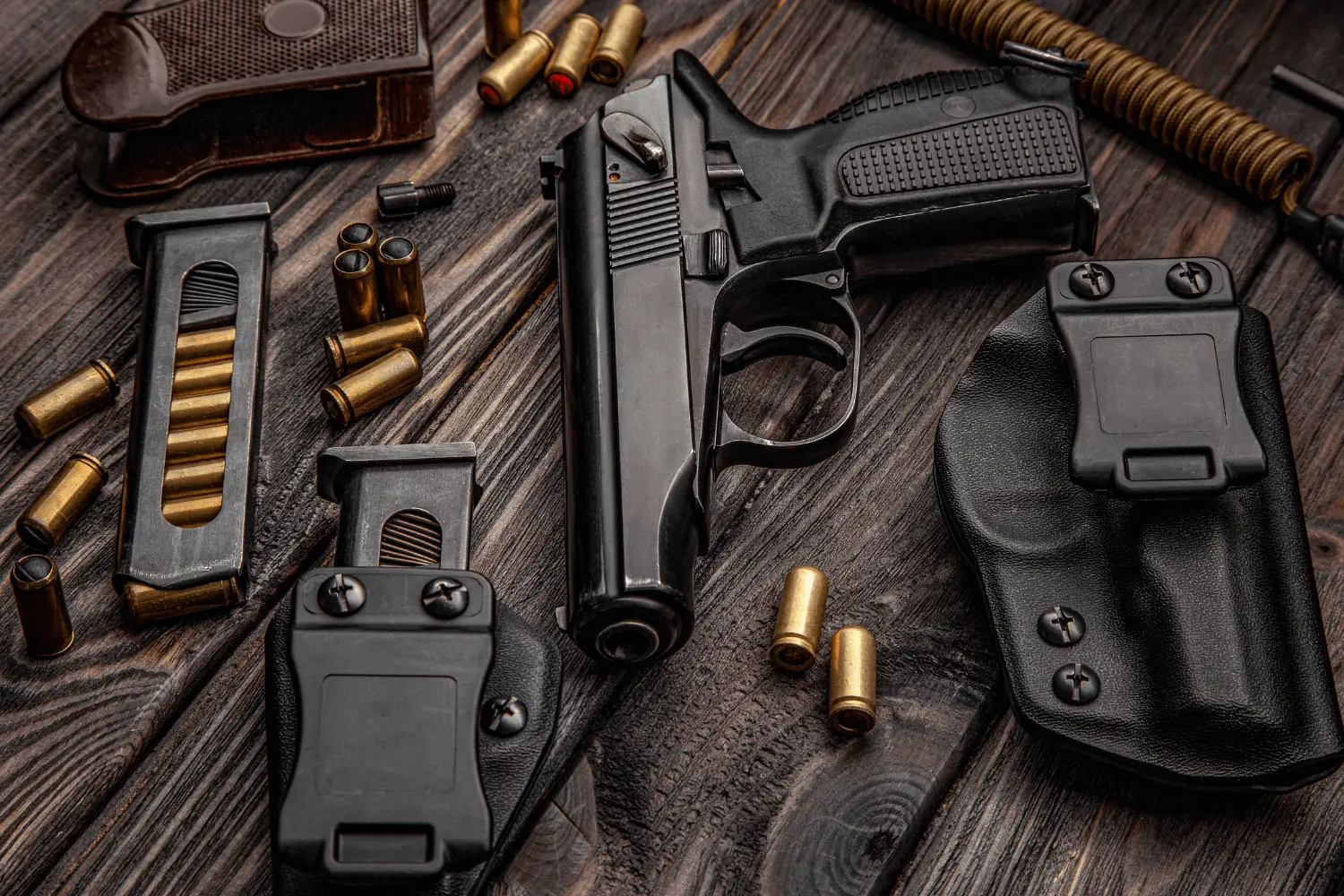 Pistol and various pistol accessories sitting on top of a wooden table