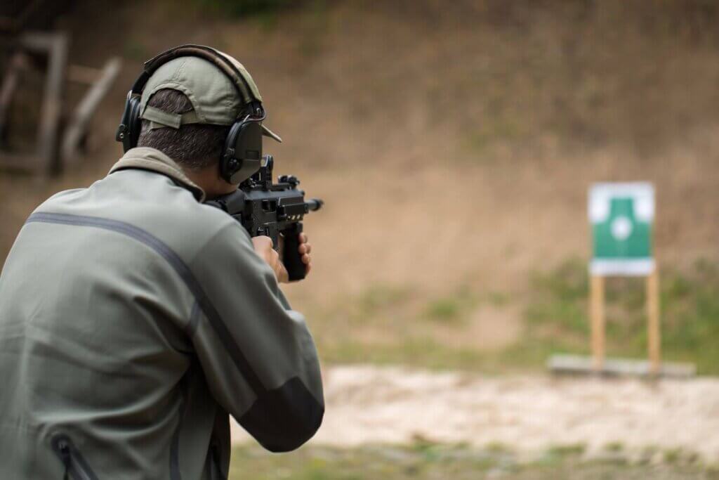 A man shooting his firearm during target practice at a shooting range
