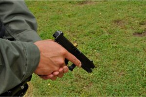 Man holding a handgun displaying a stovepipe malfunction