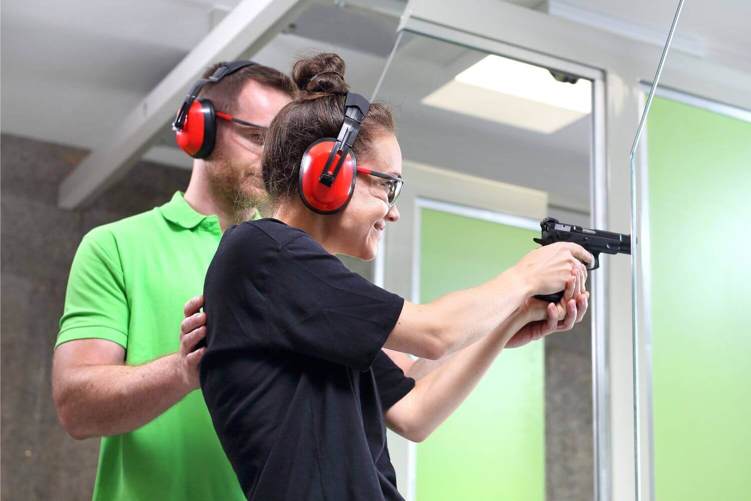 Beginner shooter practicing shooting stance with an instructor guiding her