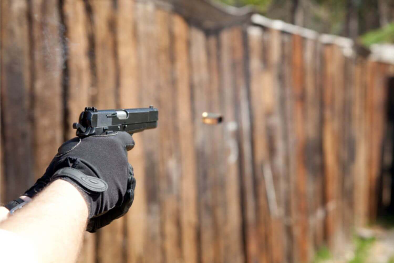 A firearm with a pull-release trigger installed is being fired at an outdoor shooting range