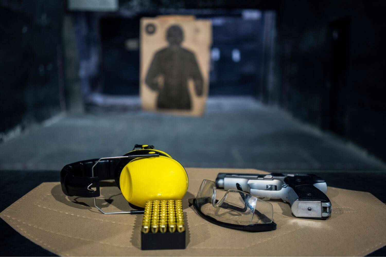 Protective eyewear and earmuffs sitting on a shooting range booth