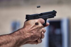 Close up view of a man shooting a pistol