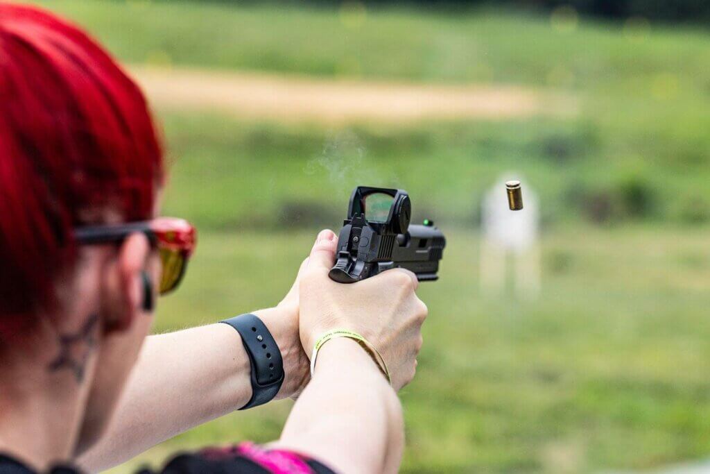 woman shooting a pistol with a Gideon Optics red dot optic mounted
